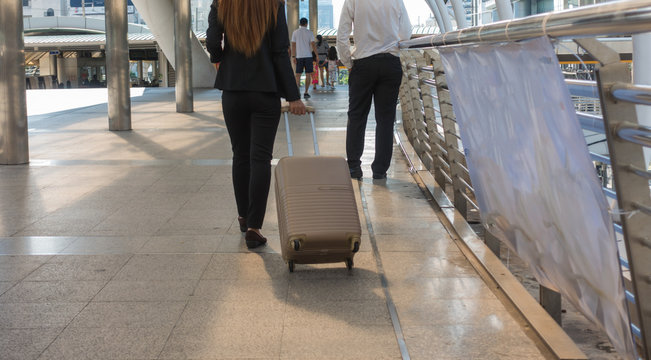 travel business woman pulling suitcase bag walking along in the
