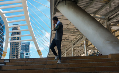 Young Asian headphone music phones while walking up the stairs.