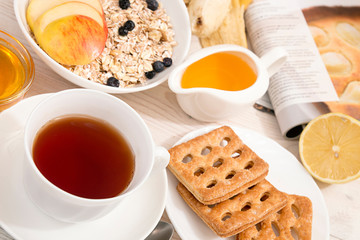Healthy breakfast. Muesli, cup of tea, honey, cookies, apple and