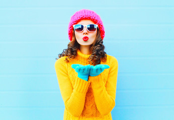 Fashion woman blowing red lips makes sends air kiss wearing a co