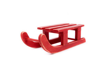 Red wooden sled, isolated on white background. Winter, Christmas, New Year wooden pine tree decoration:natural color sled, prepared from solid wood. Isolated on white  background. Side view.