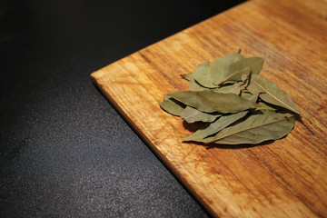 dry bay leaves on cutting wooden board