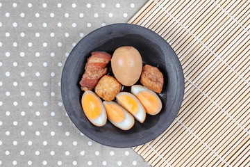 Ready stewed boiled egg with tofu and streaky pork served.