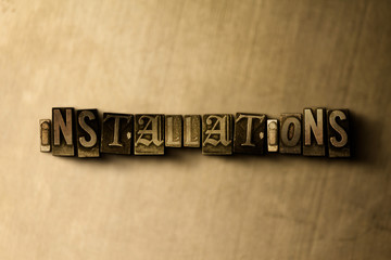 Fototapeta na wymiar INSTALLATIONS - close-up of grungy vintage typeset word on metal backdrop. Royalty free stock illustration. Can be used for online banner ads and direct mail.