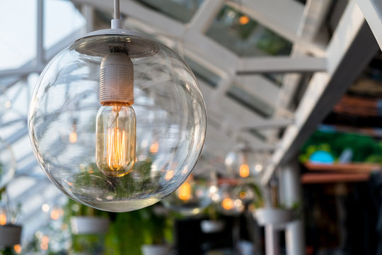 Beautiful vintage light bulb hanging down under the outdoor sun roof.
