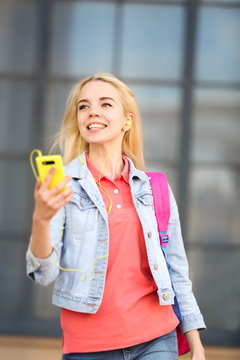 Young beautiful woman listening to music outdoor