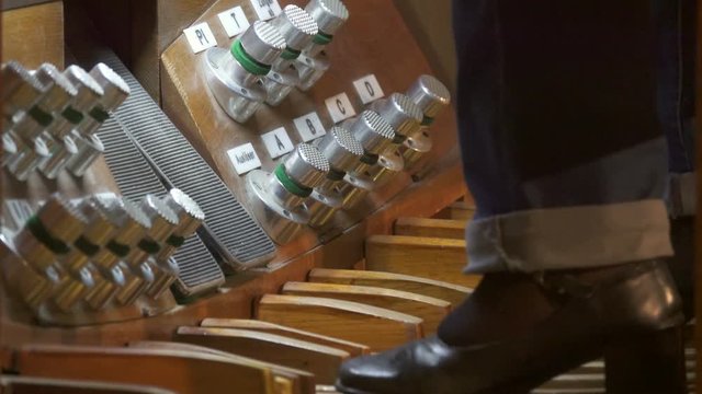 Female organist feet plays on the organ pedals, closeup