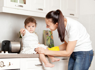 mom is busy in the kitchen with the child