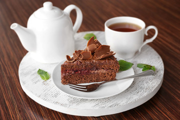 Delicious chocolate cake with tea on table