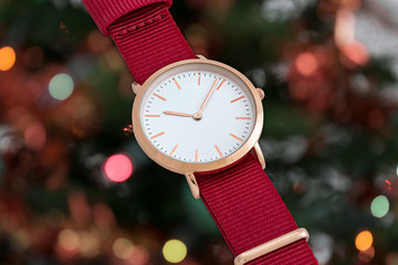 Red nylon strap wrist watch in front of Christmas lights
