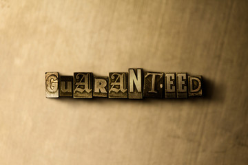 GUARANTEED - close-up of grungy vintage typeset word on metal backdrop. Royalty free stock illustration.  Can be used for online banner ads and direct mail.