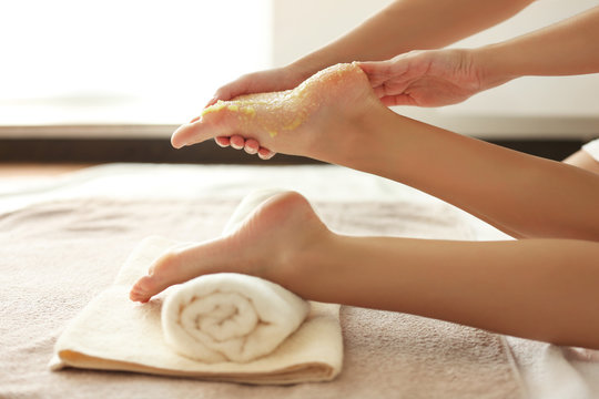 Spa concept. Hands massaging female feet with scrub
