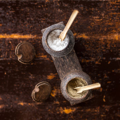 Pepper and salt in traditional balinese wooden dish on old wooden table
