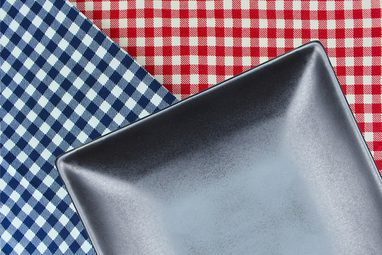 Top view plate on checkered tablecloth pattern background