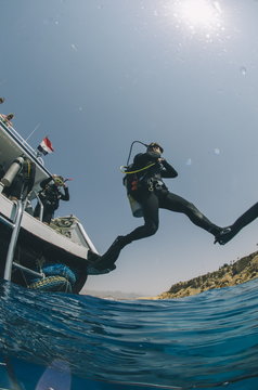 Scuba diver making giant stride entry into the water, Red Sea, Egypt