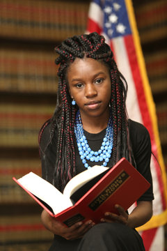 Portrait of a young attractive African American woman.  Woman lawyer in law library.