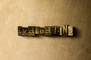 EVALUATING - close-up of grungy vintage typeset word on metal backdrop. Royalty free stock illustration.  Can be used for online banner ads and direct mail.