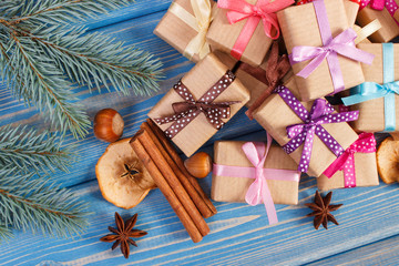 Fototapeta na wymiar Wrapped gifts with ribbons for Christmas, spices and spruce branches