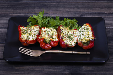 Stuffed red peppers in black plate