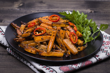 Roasted carrots in black plate, close up