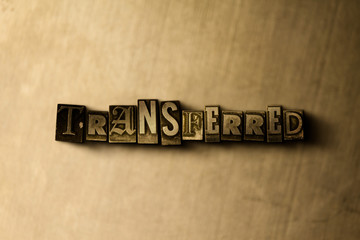TRANSFERRED - close-up of grungy vintage typeset word on metal backdrop. Royalty free stock illustration.  Can be used for online banner ads and direct mail.