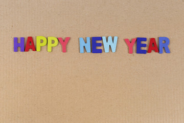 Colorful Happy new year wooden text on brown cardboard background