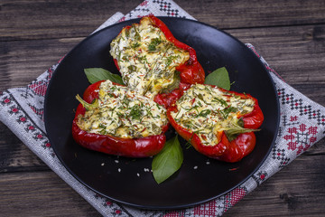 Stuffed red peppers in black plate