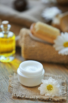Spa concept. Cream and daisy flowers on wooden table