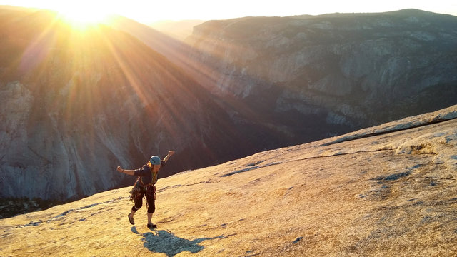 Female climber topping out of Snake Dike at sunset, Half Dome, Yosemite