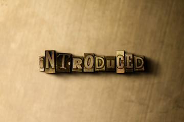 INTRODUCED - close-up of grungy vintage typeset word on metal backdrop. Royalty free stock illustration.  Can be used for online banner ads and direct mail.