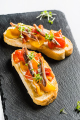 tomato and anchovy crostini on cutting board