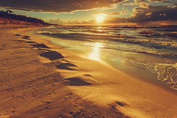 Beatiful sunset with clouds over sea and beach