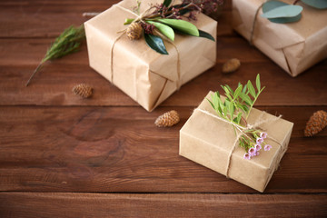 Handcrafted gift boxes with flowers on wooden table