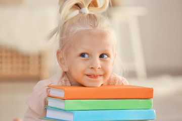 Small girl with books at home