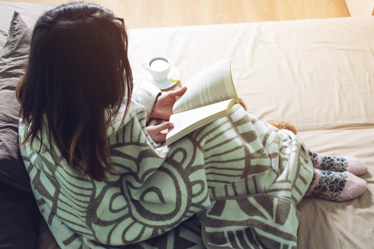Woman Wrapped In A Warm Blanket Reading Book
