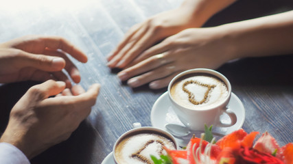 Obraz na płótnie Canvas Couple holding hands coffee cappuccino, heart