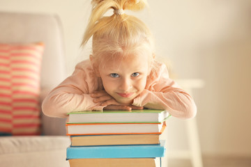 Small girl playing with books at home