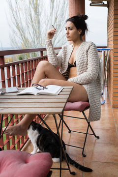 Female in lingerie and cardigan smoking