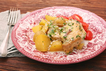 oven baked chicken fillet with potatoes and rosemary on woden table