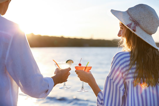 Man And Woman Holding Glasses With Margarita Cocktail On Blurred Background