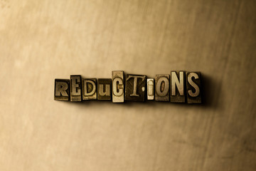 REDUCTIONS - close-up of grungy vintage typeset word on metal backdrop. Royalty free stock illustration.  Can be used for online banner ads and direct mail.