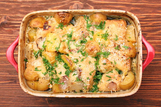 oven baked chicken fillet with potatoes and rosemary on woden table