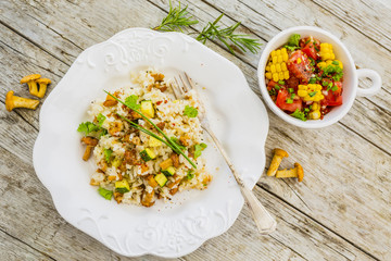Top view of risotto with chanterelle mushrooms on rustic wooden table.