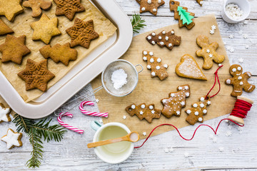 Top view of Christmas homemade gingerbreads and Christmas spices on a wooden background. 