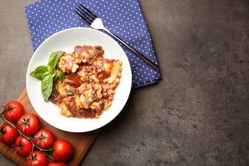 Plate of ravioli with tomato sauce on table