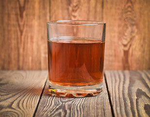 A glass of tea on wooden background.