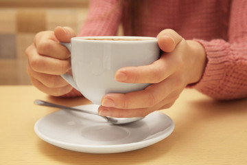Woman holding cup of coffee, closeup