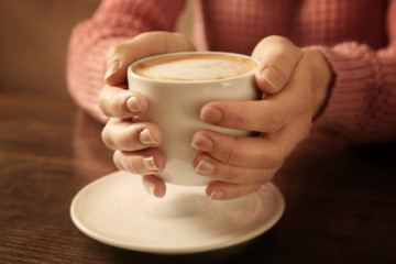 Woman holding cup of coffee, closeup