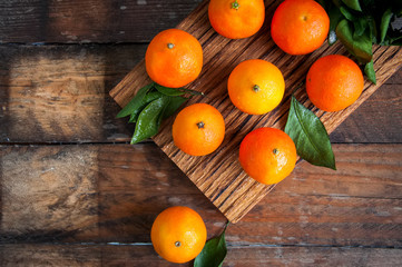 Fresh ripe mandarines on a wooden board. Wooden bacjground