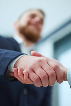 Male and female handshake in office.  Focus on hands.